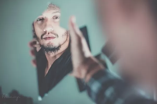 Man looking in a broken mirror