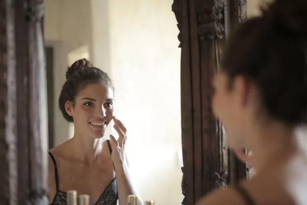 A woman applying moisturizer on her face